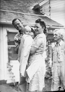 Thomas Brusveen at his parents home in Blanchardville.  His  father is the man on the right, the lady and child are unidentified.