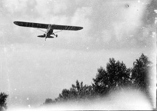 D-Day stripes painted on the underside of the spotter plane wings.